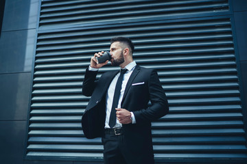 Businessman drinking hot beverage in downtown