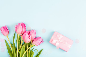 View from above tulips and gift box with copy space on blue. Background for womens day, 8 March Valentine's day, 14 february. Flat lay style, top view, mockup, template, overhead. Greeting card