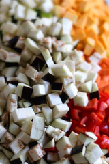 Chopped vegeatbles: eggplant, zucchini, butternut squash and red pepper. Selective focus.