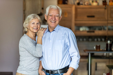 Happy senior couple embracing in their home 