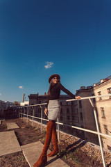 Fashion woman portrait of young pretty trendy girl in hat posing at the city in Europe, autumn street fashion.