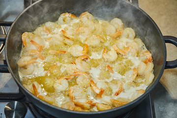 Oil-fried prawns in a pan, top view