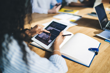 Female employee looking at chart on screen of tablet