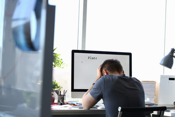 Sad upset male worker hold his head solving business problem or private life troubles at office...