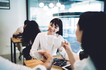 Smiling office employee listening to coworkers