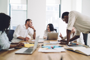 Coworkers smiling and talking during business meeting