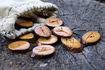 wooden runes in a bag on an old stump
