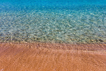 Obraz premium Yellow warm sand and summer sea with sky and free space. Sea, Sand, Sky and summer day. Beach and sea on a summer day, travel concept, vacation and relaxation. Summer sand beach and sea background.