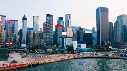 Fototapeta premium Aerial scenery panoramic view from drone of Hong Kong skyscrapers skyline with metropolitan bay. Modern concrete landscape of urban downtown with business and financial buildings. City infrastructure
