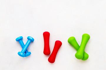 Naklejka premium Colorful dumbbells lie on concrete background. The concept of healthy lifestyle. Copy space, top view