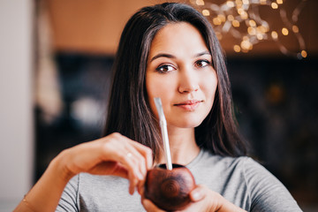 Beautiful showy brunette South American Native American authentic appearance drinks calabash mate...