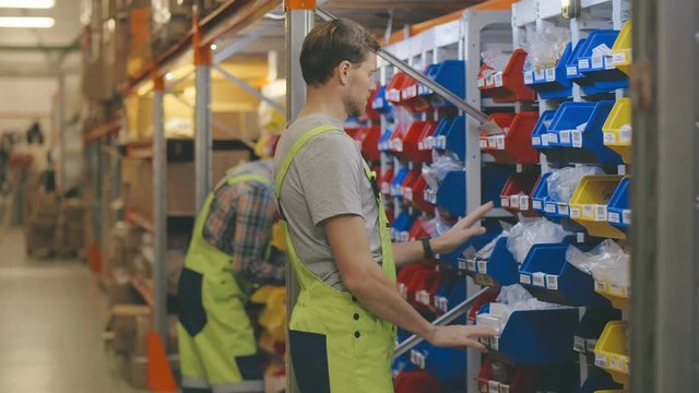 Car repair shop employees working in the warehouse for spare parts