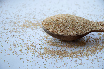 Amaranth seeds on a wooden board. Wooden spoon on a white background. Healthy food, best breakfast. Food.