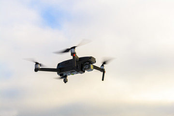 Running drone into the sky, quadcopter on blue sky background.