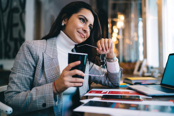 Confident freelancer drinking beverage at workplace