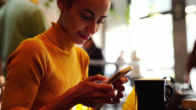 Phone - young beautiful Woman sms texting using app on smart phone in caffee. Closeup of hands using smartphone outdoors. Mobile cell phone close up.