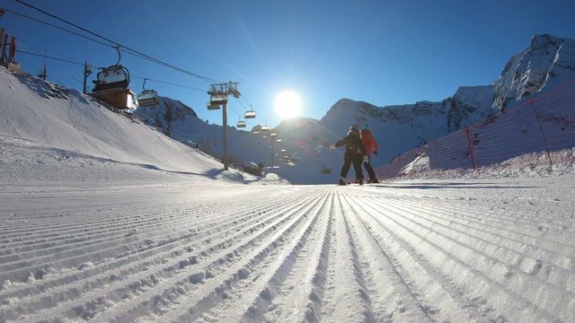 ski instructor with a student on a freshly prepared track with corduroy conduct classes making the first turns. Winter fun at the ski resort. video footage