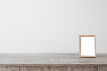 wooden frame on wooden table on background white wall