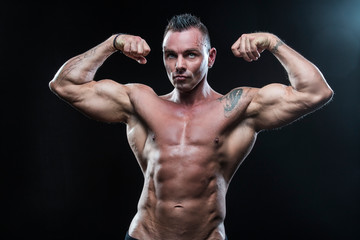 Fototapeta na wymiar Male bodybuilder with an athletic build on a dark background.athlete, exercise, health, power, strength, man,