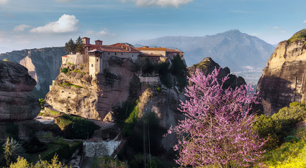Fototapeta na wymiar Scenic image of spring Landscape Monastery Meteora Greece. Stunning spring panoramic landscape. View at mountains and blossoming trees during sunrise. Wonderful nature scene