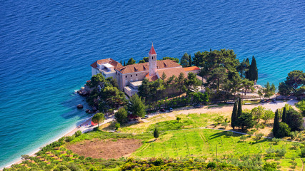 Naklejka premium View of beautiful bay with beach and Dominican monastery in Bol town, Brac island, Croatia. Dominican monastery in Bol, built in 15th century. Bol town, Brac island, Croatia.