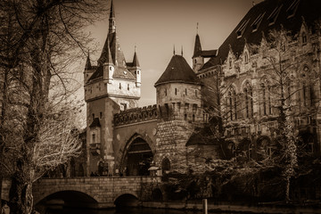 Fototapeta na wymiar Dark view of old castle, one of the romantic castles in Budapest, Hungary, located in the City Park by the boating lake / skating rink