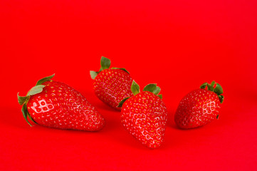 Strawberry ripe and juicy, very tasty and healthy, shot large on a bright red background