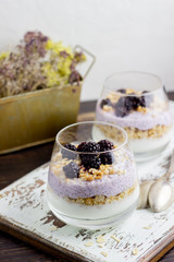Yogurt with granola, chia seeds and blackberries on a wooden background. Breakfast. Healthy eating.