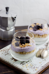 Yogurt with granola, chia seeds and blackberries on a wooden background. Breakfast. Healthy eating.
