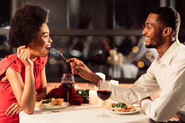 Happy Couple Feeding Each Other Celebrating Valentine's Day In Restaurant