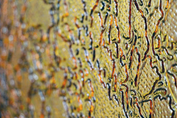 Colored glass. Gold and brown background. The texture of the glass. Yellow patterns. Design.