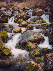 Fototapeta na wymiar Long exposure waterfall over rocks in forest landscape
