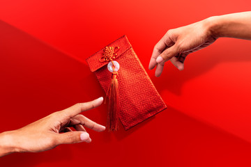 Hands reaching for Red Envelope