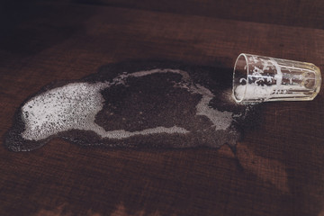 Alcoholism in the family. Beer bottle and spilled beer in the sofa.