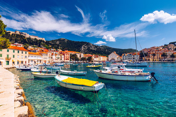 Fototapeta premium View at amazing archipelago with boats in front of town Hvar, Croatia. Harbor of old Adriatic island town Hvar. Popular touristic destination of Croatia. Amazing Hvar city on Hvar island, Croatia.