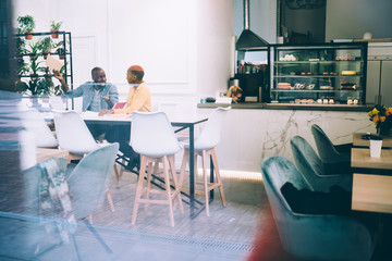 Black employees working at table in cafe