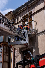 Fototapeta na wymiar Firefighters uploaded on an elevating platform, attending an emergency