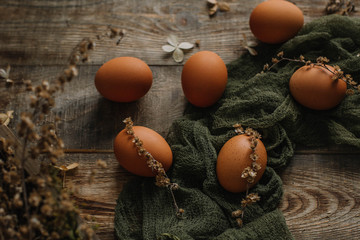 Eggs without staining on a wooden background in gauze in a rustic style