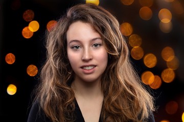 Face of woman with brown hair and gray eyes on lights background