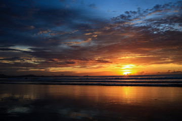 Naklejka na ściany i meble Seascape with a vibrant sunset over a calm sea