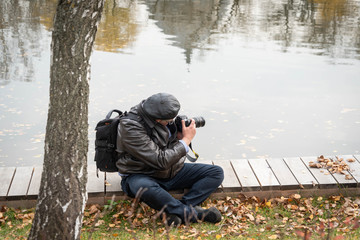 Fototapeta premium man sitting on bench in autumn park