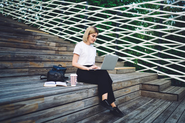 Elegant woman interacting with laptop on street