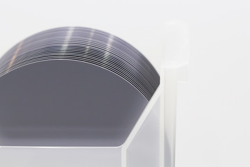 Silicon Wafers in white plastic holder box on a table- A wafer is a thin slice of semiconductor...