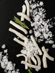  sliced ​​squid with rosemary on a black background