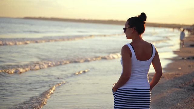 Portrait of woman looking at sea. Rear view of young woman looking at sea