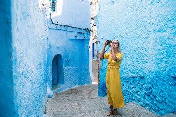 Young tourist with camera traveling in street