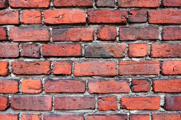 Grunge red brick wall with textured blocks, selective focus. Old stone wall. Red bricks background. Construction works.  Brickwork. 