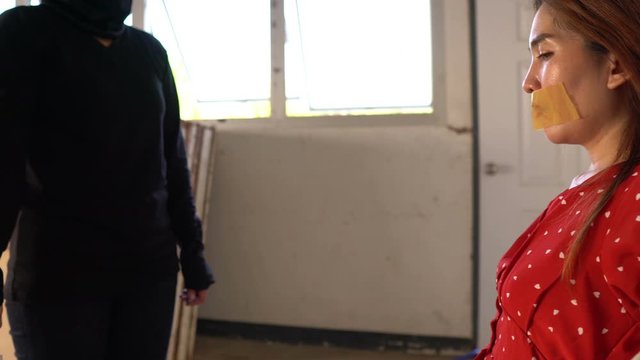 Asian hostage woman Bound with rope at night scene,The thieves kidnapped for ransom,thailand people	