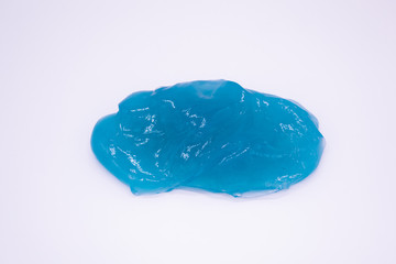 Close up of a light blue slime on a white background. The mucus is crushed, stretched, torn and squeezed, anti-stress toy 