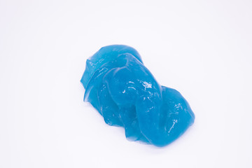 Close up of a light blue slime on a white background. The mucus is crushed, stretched, torn and squeezed, anti-stress toy 